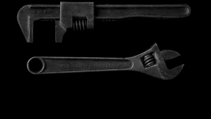 gray adjustable wrench and gray pipe wrench