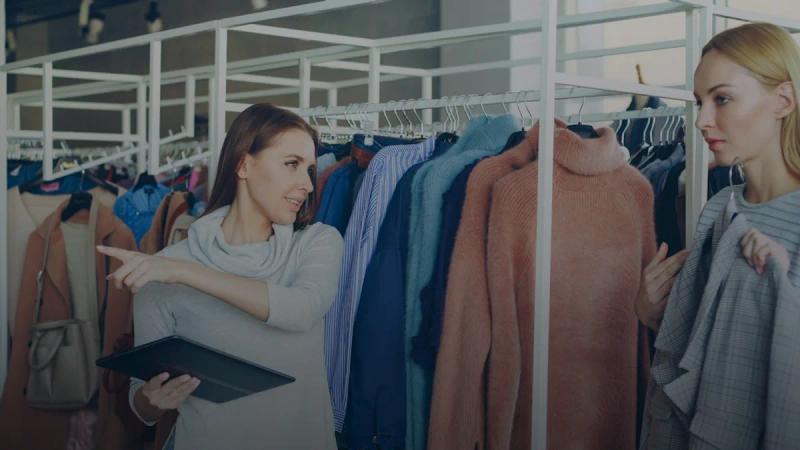 A woman helps another pick out clothes