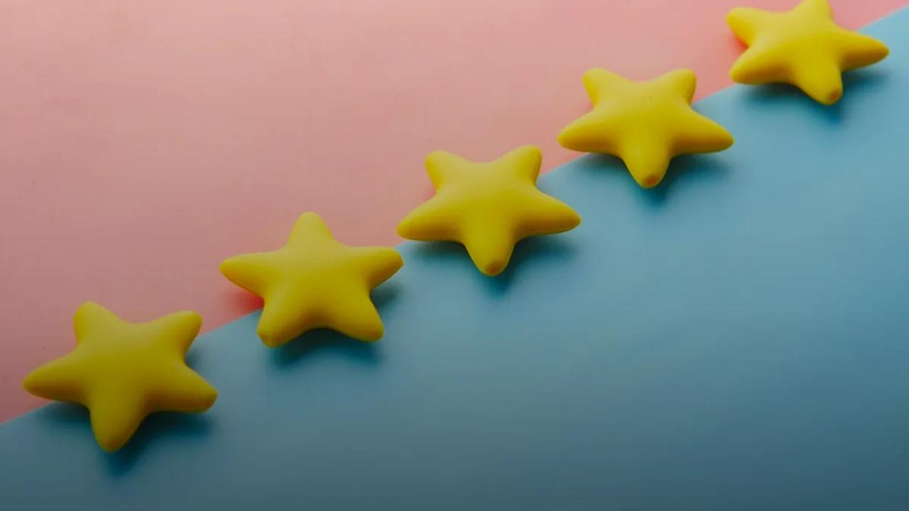 a row of yellow stars sitting on top of a blue and pink surface