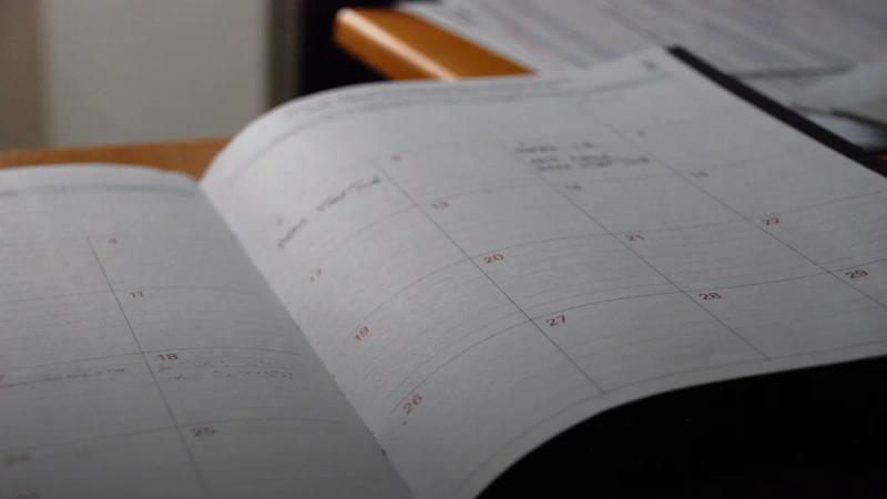 open monthly planner on wooden desk