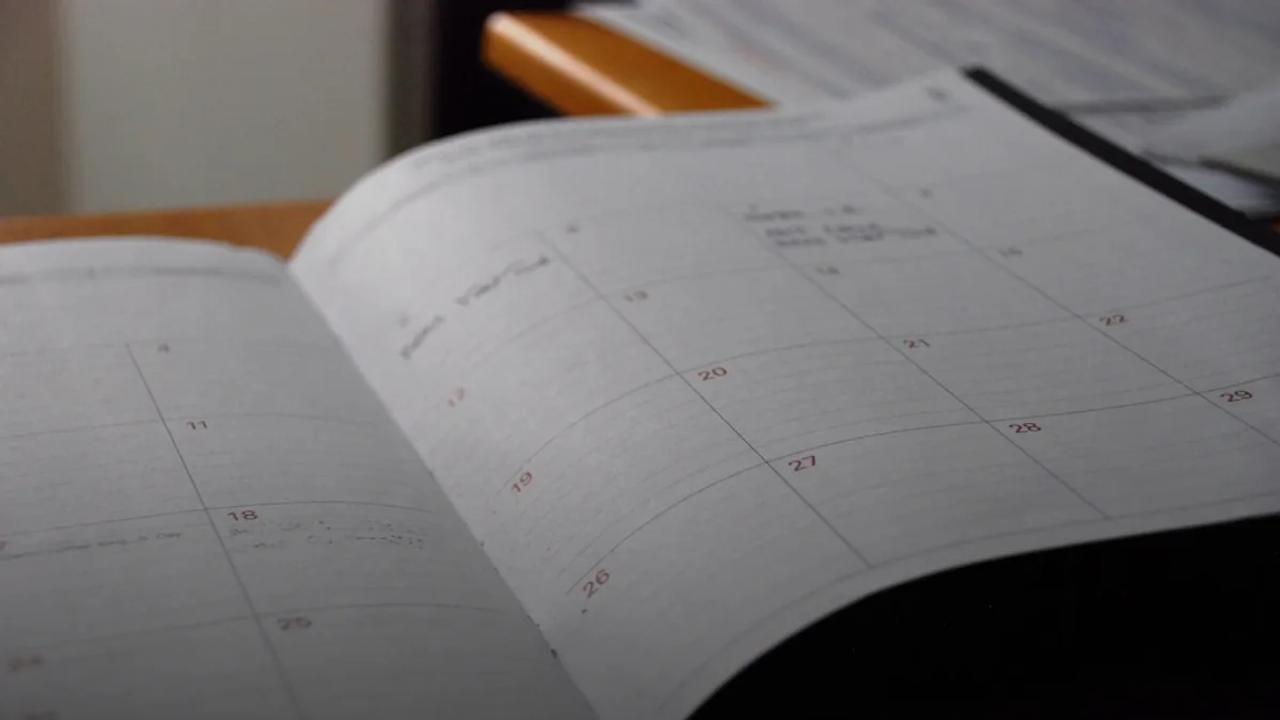 open monthly planner on wooden desk