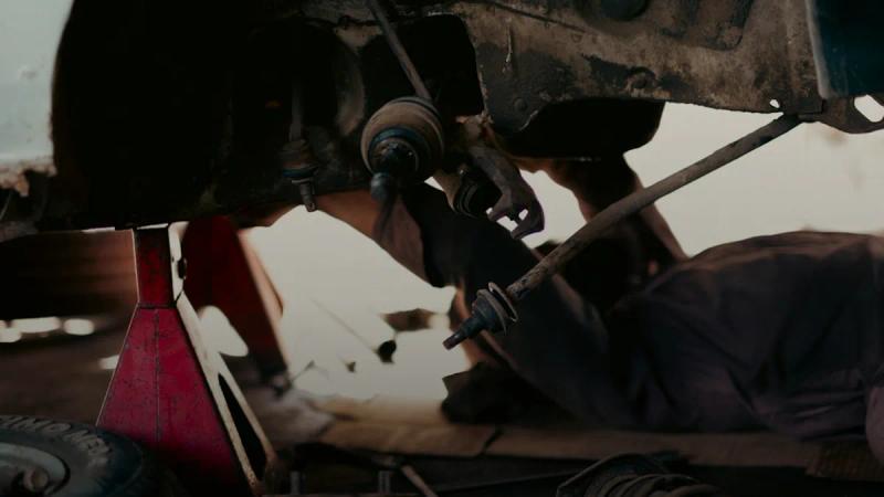 a man working on a car under a vehicle