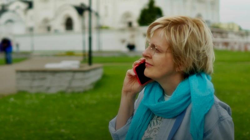 A woman talks on the phone outside