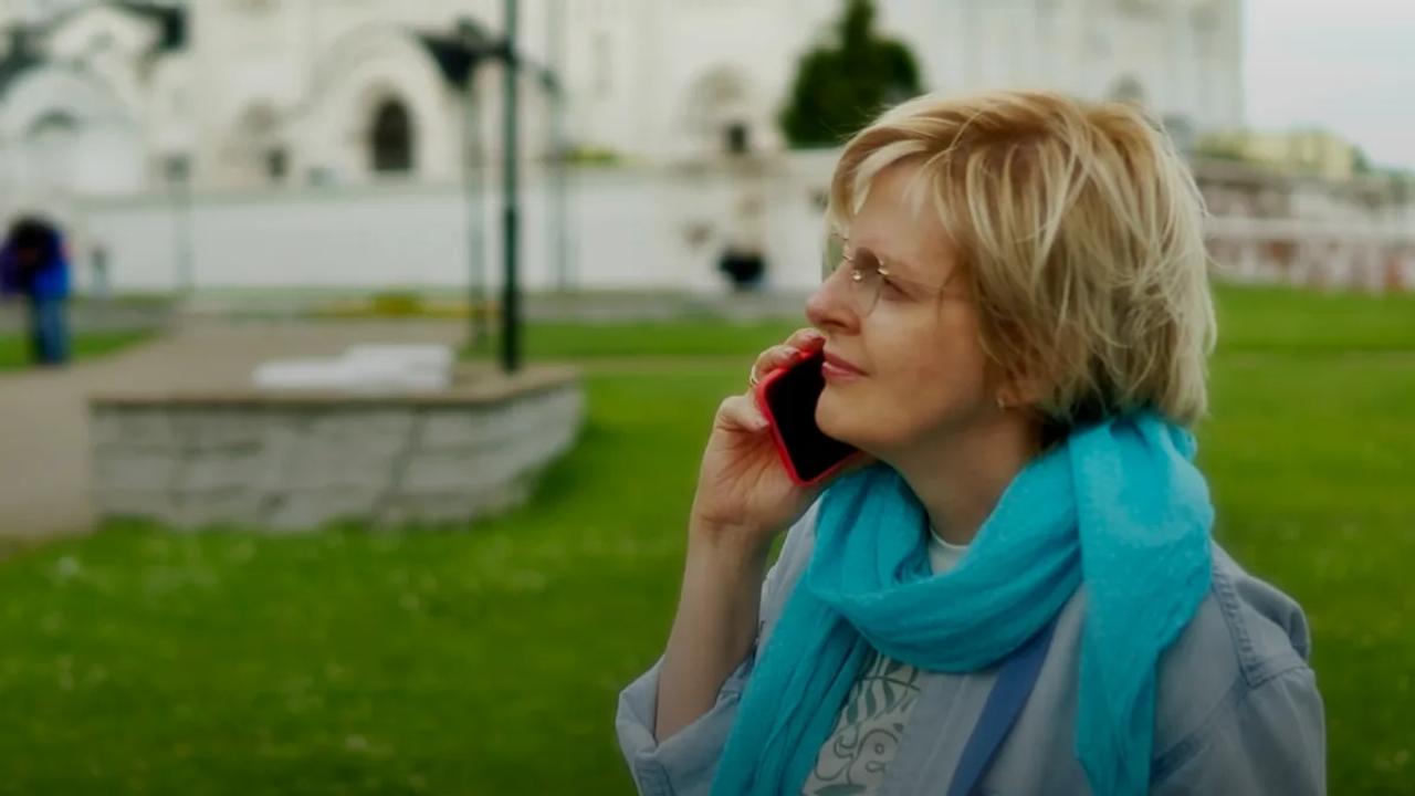 A woman talks on the phone outside