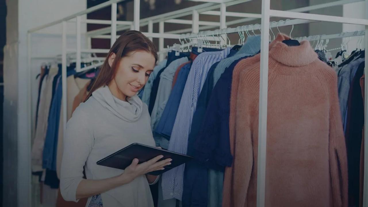 Woman uses a tablet in a clothing store.