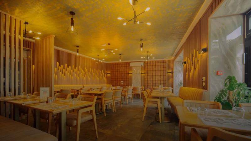 Modern restaurant interior with warm lighting and seating.