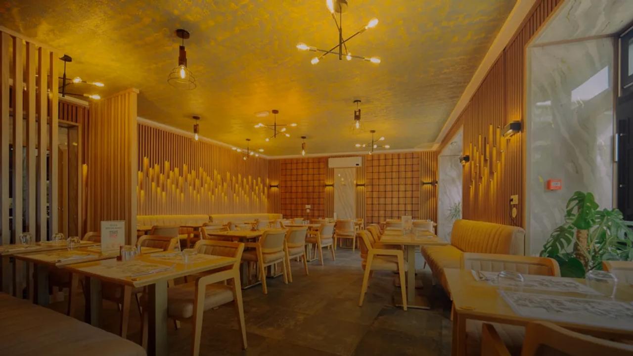Modern restaurant interior with warm lighting and seating.