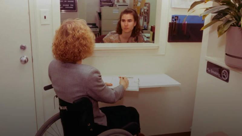 a woman sitting in a wheel chair in front of a mirror