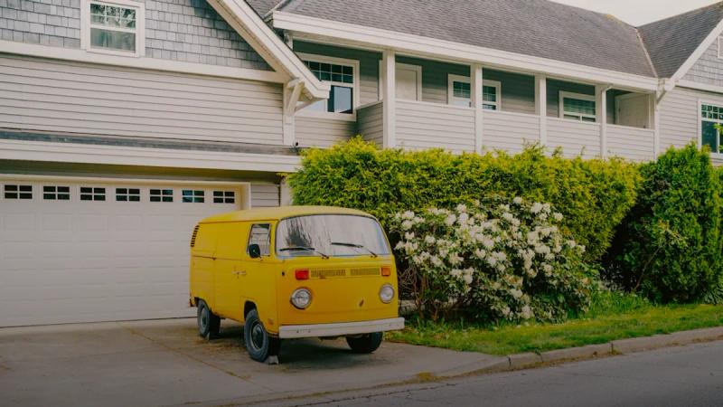 a yellow van parked in front of a house