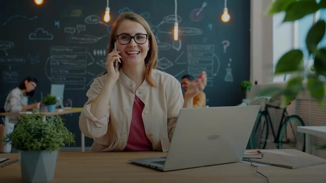 Smiling woman talking on phone in modern office