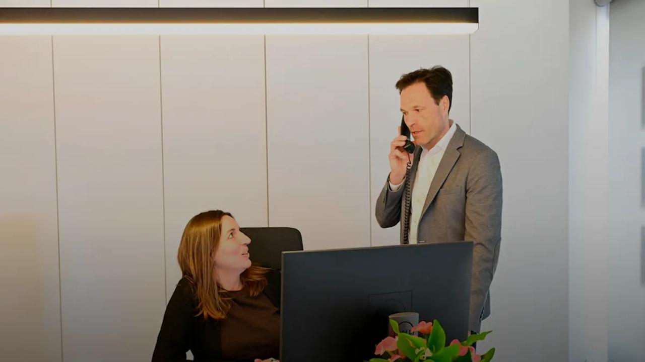 Businessman on phone with woman in modern office