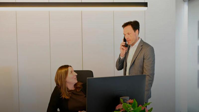 Businessman on phone with woman in modern office