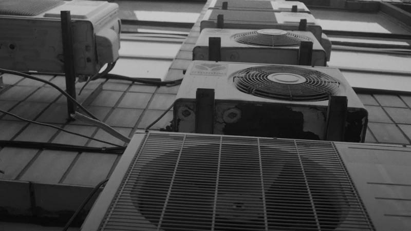 a row of air conditioners sitting on top of a tiled floor