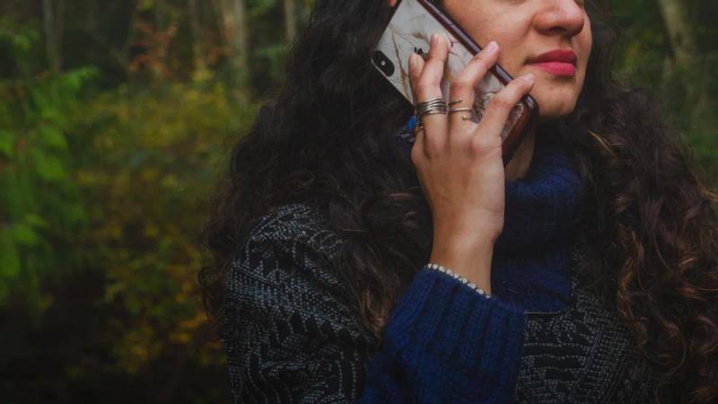 woman in blue sweater holding smartphone