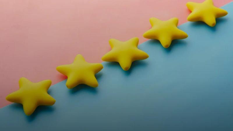 a row of yellow stars sitting on top of a blue and pink surface