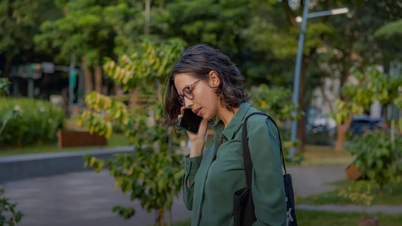 a woman talking on a cell phone in a park