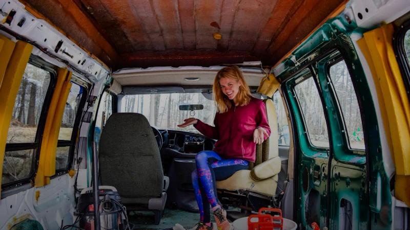 woman in red long sleeve shirt and blue denim jeans sitting on green van