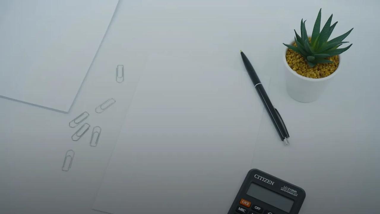 black calculator beside black pen on white printer paper